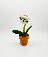 Needle felted plant in pot with red and white dotted head, white eyes and white teeth
