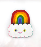 Hand carved wooden sculpture of a rainbow and a white cloud with eyes and a smiling mouth, painted with acrylic paint