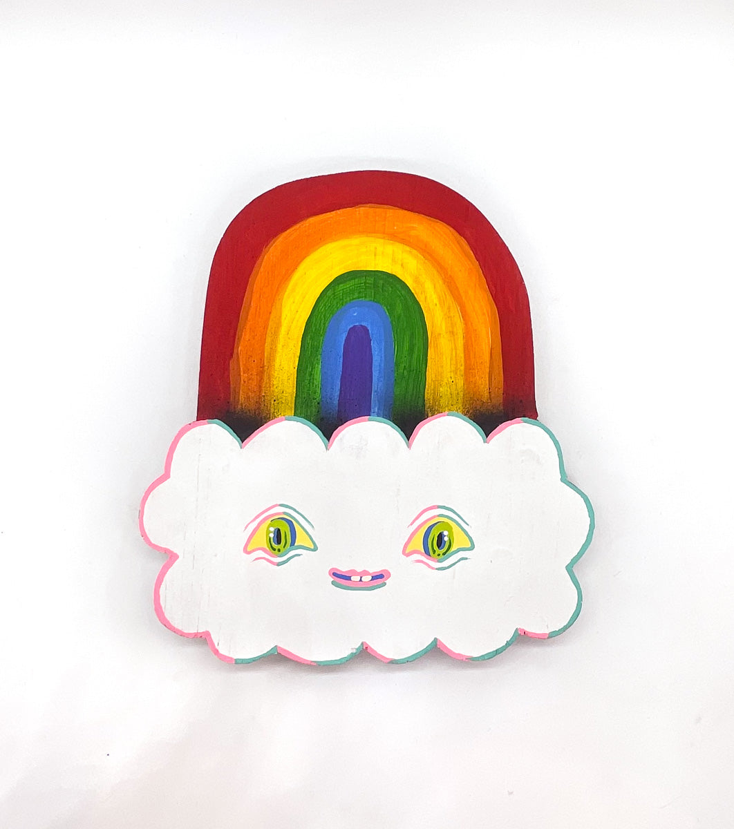 Hand carved wooden sculpture of a rainbow and a white cloud with eyes and a smiling mouth, painted with acrylic paint