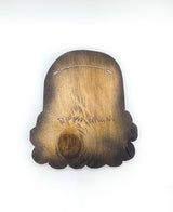 Hand carved wooden sculpture of a rainbow and a white cloud with eyes and a smiling mouth, painted with acrylic paint, the blank wooden back side with the artist's signature