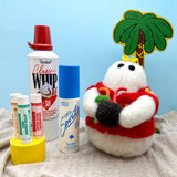 Hand felted small white ghost in a red Hawaiian style shirt holding a coconut cocktail, surrounded by beach props